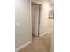 Hallway with neutral walls and carpet leads to an open door at 8189 Roseville Rd, Davenport, FL 33896