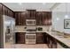 Well-equipped kitchen featuring stainless steel appliances, granite countertops, and dark wood cabinets at 8189 Roseville Rd, Davenport, FL 33896