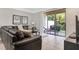 Relaxing living room featuring a gray sectional couch and sliding glass doors to the outdoor patio at 8189 Roseville Rd, Davenport, FL 33896