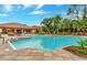 Stunning community pool with lounge chairs, lush landscaping, and a beautiful clubhouse in the background at 8189 Roseville Rd, Davenport, FL 33896