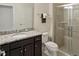 Clean bathroom with granite countertop, dark brown vanity, and shower at 8896 Bengal Ct, Kissimmee, FL 34747
