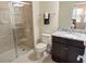 Clean bathroom with granite countertop, dark brown vanity, and shower at 8896 Bengal Ct, Kissimmee, FL 34747