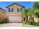 Two-story house with a beige facade, a brick driveway, and lush landscaping at 8896 Bengal Ct, Kissimmee, FL 34747