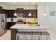 Updated kitchen with dark cabinetry, granite island, and stainless steel appliances at 8896 Bengal Ct, Kissimmee, FL 34747