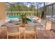Screened patio with pool, table, chairs, and grill at 8896 Bengal Ct, Kissimmee, FL 34747