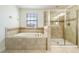 Clean bathroom with a large soaking tub and shower at 9024 Shadow Mountain St, Davenport, FL 33896