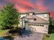 Two-story house with a three-car garage and a landscaped front yard at 9024 Shadow Mountain St, Davenport, FL 33896