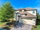 Two-story home with tile roof, paver driveway and landscaping at 9024 Shadow Mountain St, Davenport, FL 33896