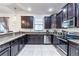 Modern kitchen with dark cabinets, granite countertops, and stainless steel appliances at 9024 Shadow Mountain St, Davenport, FL 33896