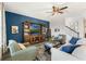 Living room with blue accent wall, comfortable seating, and large TV at 9459 Jaywood Rd, Winter Garden, FL 34787