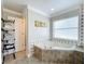 Elegant bathroom featuring a soaking tub with jets, a large window, and a towel rack at 10010 Crenshaw Cir, Clermont, FL 34711