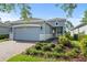 Single-story home with gray exterior, two-car garage, and landscaped front yard at 1069 Avery Meadows Way, Deland, FL 32724