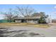 Gray brick ranch house with mature trees, a shed, and a large yard at 1201 Carol Ave, Auburndale, FL 33823
