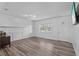 Bright living room featuring wood-look floors and a wall of wainscoting at 1201 Carol Ave, Auburndale, FL 33823