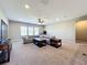 Spacious living room featuring neutral carpet, gray sectional, ceiling fan, and natural light at 13870 Jomatt Loop, Winter Garden, FL 34787