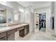 Elegant bathroom with double sinks, large mirror and walk-in closet at 15267 Aquarius Way, Mascotte, FL 34753