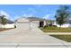 Three car garage home with a well manicured lawn at 15267 Aquarius Way, Mascotte, FL 34753
