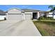 Two-story house with three car garage and landscaped yard at 15267 Aquarius Way, Mascotte, FL 34753