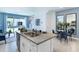 Open kitchen with island and granite countertops, overlooking living and dining areas at 1543 Isleta Loop, Kissimmee, FL 34741