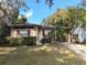 Charming bungalow featuring a well-manicured lawn, mature trees, and a convenient carport at 1825 Park Lake St, Orlando, FL 32803