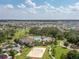 Aerial view showcasing the community pool, clubhouse, playground, and volleyball court in a lush, landscaped setting at 1882 Rustic Falls Dr, Kissimmee, FL 34744