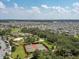 Aerial shot of community amenities: pool, clubhouse, tennis courts, and playground amidst green spaces and residences at 1882 Rustic Falls Dr, Kissimmee, FL 34744