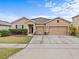 Charming single-story home featuring a well-manicured lawn and a two-car garage at 1882 Rustic Falls Dr, Kissimmee, FL 34744