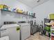 Well-organized laundry room featuring modern washer and dryer and ample storage shelving at 1882 Rustic Falls Dr, Kissimmee, FL 34744