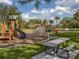 Inviting playground with slides, swings, and a picnic table, set in a lush community park with mature landscaping at 1882 Rustic Falls Dr, Kissimmee, FL 34744