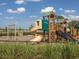 Modern playground with slides, climbing structures, and swings, set in a safe, -friendly environment at 1882 Rustic Falls Dr, Kissimmee, FL 34744