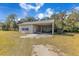 White equipment shed with metal roof and various equipment inside at 2140 W State Road 46, Geneva, FL 32732
