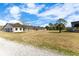 Long, light-colored stable with numerous stalls and a gravel path at 2140 W State Road 46, Geneva, FL 32732