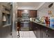 Dark wood cabinets, granite countertops, and stainless steel appliances at 245 Scottsdale Sq # 245, Winter Park, FL 32792