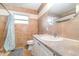 Cozy bathroom with tiled walls, a neutral color scheme, and a sink with a mirror at 24908 County Road 561, Astatula, FL 34705