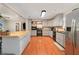 Well-lit kitchen with stainless steel appliances, ample cabinet space, and hardwood floors at 24908 County Road 561, Astatula, FL 34705