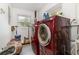 Practical laundry room featuring new red washer and dryer units with a window for natural light at 24908 County Road 561, Astatula, FL 34705
