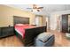 Spacious main bedroom with a ceiling fan, wood floors, and a dark wood bed frame with red comforter at 24908 County Road 561, Astatula, FL 34705