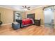 Main bedroom featuring a ceiling fan, wood floors, and a dark wood bed frame with red comforter at 24908 County Road 561, Astatula, FL 34705