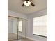 This bedroom includes light gray walls, laminate flooring, a window with blinds, and sliding closet doors at 3208 Oak Lawn Pl # 218, Winter Park, FL 32792