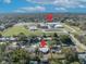 An aerial view of the neighborhood showing nearby school and tree-lined streets under a sunny, partly cloudy sky at 3309 Drake Dr, Orlando, FL 32810