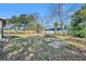Large backyard with partial grass, fence, and an outdoor brick fire pit at 3309 Drake Dr, Orlando, FL 32810