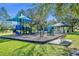 An exterior view of a modern playground with a blue slide, swings, and benches in a public park on a sunny day at 3309 Drake Dr, Orlando, FL 32810