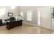 Home office with a large dark wood desk, tile flooring, and natural light from the window at 341 Skyview Pl, Chuluota, FL 32766