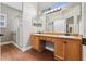 Bathroom featuring double sinks, vanity lighting and glass enclosed shower at 3608 Mount Hope Loop, Leesburg, FL 34748