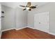 A room with wood floors, gray walls, a ceiling fan with a light, and a double door closet at 3608 Mount Hope Loop, Leesburg, FL 34748