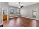 Spacious bedroom with ceiling fan, wood floor, and view to ensuite bathroom and exterior at 3608 Mount Hope Loop, Leesburg, FL 34748