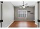 This bedroom features light gray walls, wood floors, a ceiling fan with light and a window with shutters at 3608 Mount Hope Loop, Leesburg, FL 34748