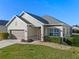 Well-manicured front lawn and shrubbery complement the home's neutral tones and well-kept two car garage at 3608 Mount Hope Loop, Leesburg, FL 34748