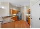 Well-lit kitchen features stainless steel appliances, wood cabinets and wood flooring at 3608 Mount Hope Loop, Leesburg, FL 34748