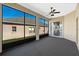 Enclosed lanai with gray carpet, a ceiling fan with a light and view of the back of the home at 3608 Mount Hope Loop, Leesburg, FL 34748
